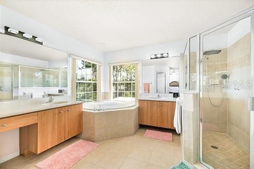 7 Flint Pl, Palm Coast, FL 32137 - full bathroom featuring a shower stall, two vanities, a garden tub, and tile patterned floors