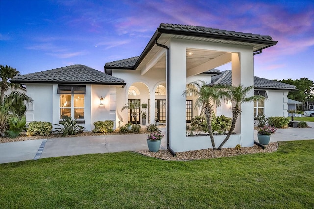 33 Crystal Bay Ct, Palm Coast, FL 32137 - back of property featuring a tiled roof, stucco siding, a yard, and french doors