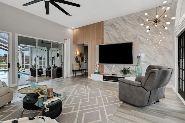 33 Crystal Bay Ct, Palm Coast, FL 32137 - living room featuring an accent wall, a ceiling fan, a chandelier, and wood finished floors