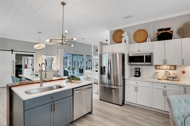 33 Crystal Bay Ct, Palm Coast, FL 32137 - kitchen featuring stainless steel appliances, a barn door, decorative backsplash, light countertops, and light wood-style flooring