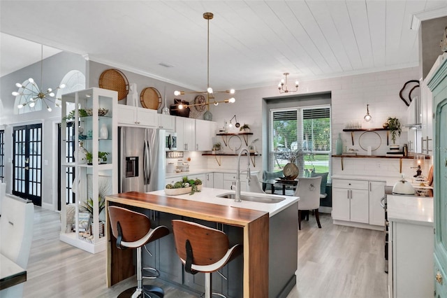 33 Crystal Bay Ct, Palm Coast, FL 32137 - kitchen with open shelves, a chandelier, stainless steel appliances, light countertops, and light wood-type flooring