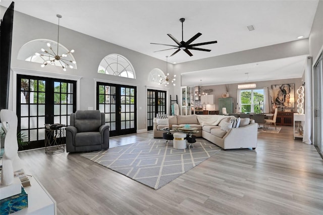 33 Crystal Bay Ct, Palm Coast, FL 32137 - living room featuring french doors, a chandelier, wood finished floors, a high ceiling, and recessed lighting
