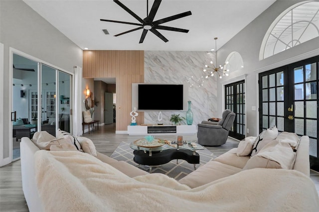 33 Crystal Bay Ct, Palm Coast, FL 32137 - living area with french doors, an accent wall, a ceiling fan, wood finished floors, and a chandelier