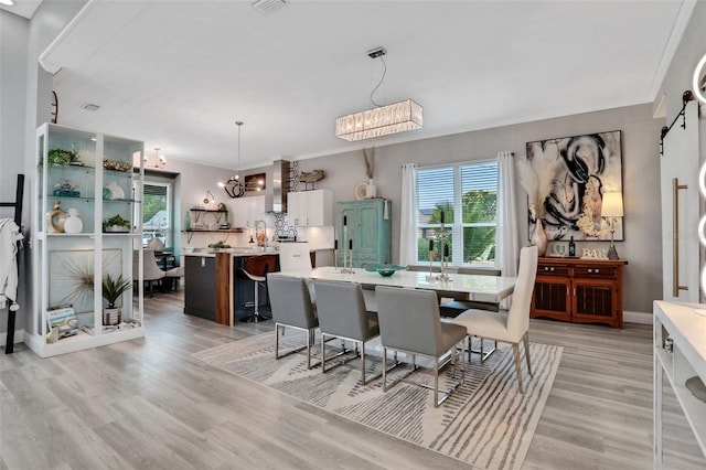 33 Crystal Bay Ct, Palm Coast, FL 32137 - dining area featuring a chandelier, a barn door, and light wood finished floors