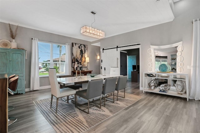 33 Crystal Bay Ct, Palm Coast, FL 32137 - dining area featuring a barn door, wood finished floors, and ornamental molding