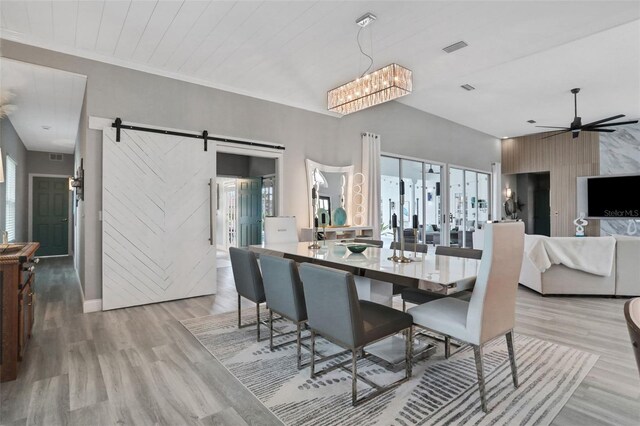 33 Crystal Bay Ct, Palm Coast, FL 32137 - dining space with a barn door, light wood-type flooring, ceiling fan, and a chandelier