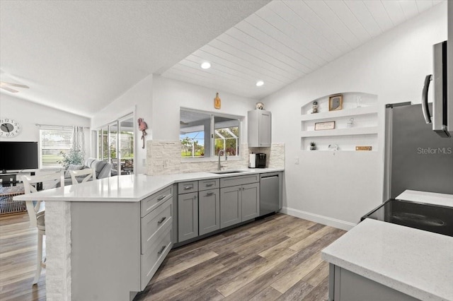1904 Rouzbeh Ct, Port Orange, FL 32128 - kitchen featuring gray cabinets, stainless steel appliances, lofted ceiling, decorative backsplash, and light wood finished floors
