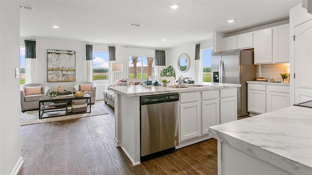 8 Mill Wheel Ct S, Palm Coast, FL 32137 - kitchen featuring stainless steel appliances, dark wood-style flooring, white cabinetry, a kitchen island with sink, and recessed lighting
