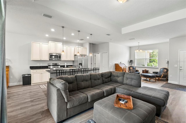 9 Elder Pl, Palm Coast, FL 32164 - living room featuring light wood-style floors, recessed lighting, and a chandelier