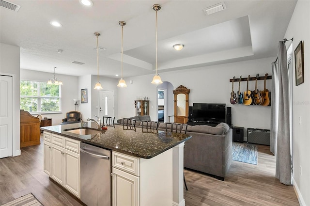 9 Elder Pl, Palm Coast, FL 32164 - kitchen with stainless steel dishwasher, wood finished floors, open floor plan, dark stone countertops, and an island with sink