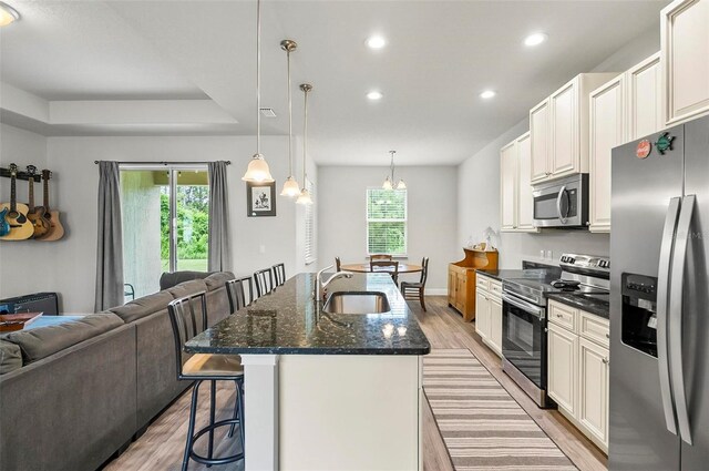 9 Elder Pl, Palm Coast, FL 32164 - kitchen with stainless steel appliances, light wood-style floors, a breakfast bar, open floor plan, and recessed lighting