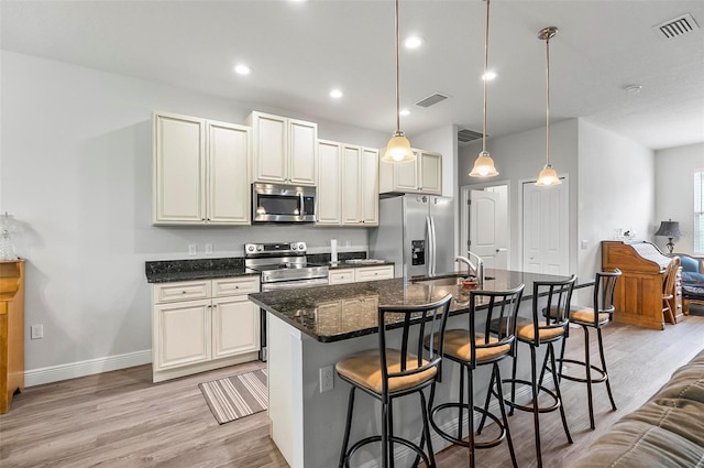 9 Elder Pl, Palm Coast, FL 32164 - kitchen featuring appliances with stainless steel finishes, light wood-style floors, a center island with sink, a kitchen breakfast bar, and recessed lighting