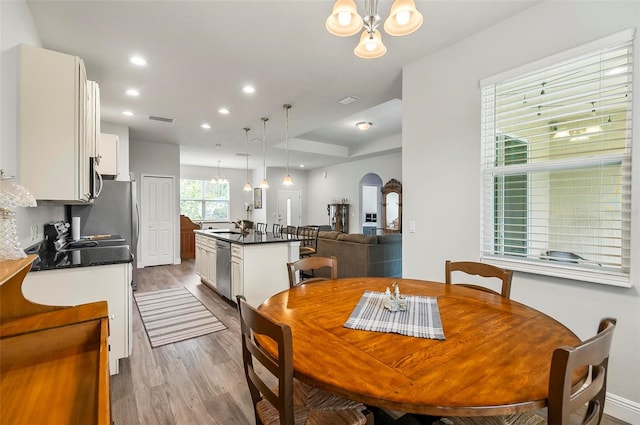 9 Elder Pl, Palm Coast, FL 32164 - dining area featuring a chandelier, wood finished floors, arched walkways, and recessed lighting