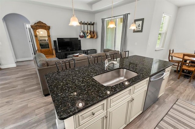 9 Elder Pl, Palm Coast, FL 32164 - kitchen featuring light wood finished floors, dishwasher, arched walkways, open floor plan, and dark stone countertops