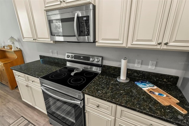 9 Elder Pl, Palm Coast, FL 32164 - kitchen featuring stainless steel appliances, light wood-style flooring, and dark stone countertops