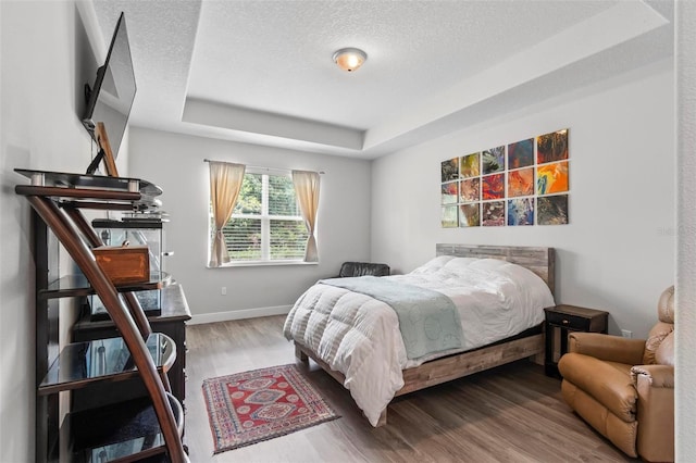 9 Elder Pl, Palm Coast, FL 32164 - bedroom featuring wood finished floors, a textured ceiling, and a raised ceiling