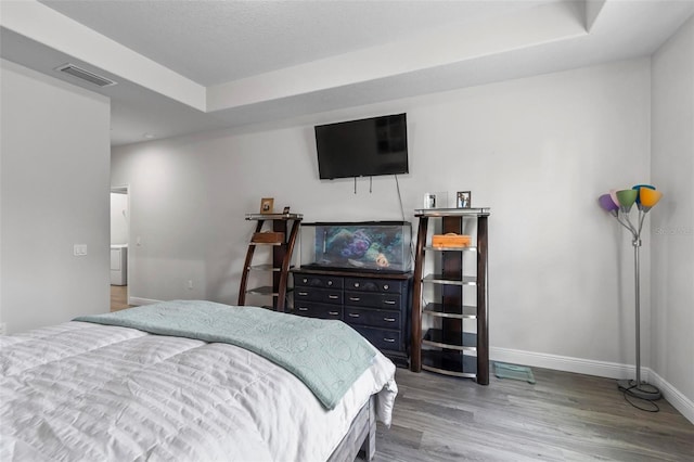 9 Elder Pl, Palm Coast, FL 32164 - bedroom featuring wood finished floors, a tray ceiling, and washer / dryer