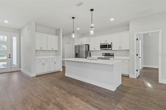1 Barbera Ln, Palm Coast, FL 32137 - kitchen with dark wood finished floors, stainless steel appliances, a center island with sink, white cabinets, and recessed lighting