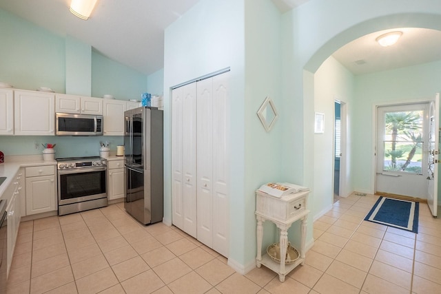47 Summerwind Cir, Palm Coast, FL 32137 - kitchen featuring appliances with stainless steel finishes, arched walkways, light tile patterned flooring, light countertops, and high vaulted ceiling