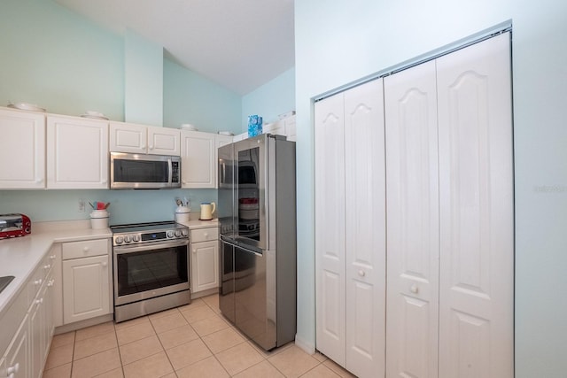 47 Summerwind Cir, Palm Coast, FL 32137 - kitchen featuring stainless steel appliances, lofted ceiling, light tile patterned floors, white cabinetry, and light countertops