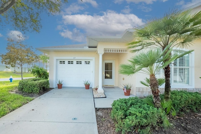 47 Summerwind Cir, Palm Coast, FL 32137 - view of front of house featuring stucco siding, an attached garage, and driveway
