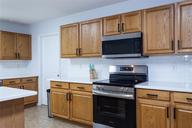 32 Karas Trl, Palm Coast, FL 32164 - kitchen featuring stainless steel appliances, brown cabinets, backsplash, and light countertops