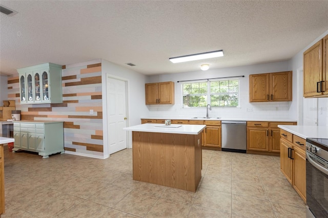 32 Karas Trl, Palm Coast, FL 32164 - kitchen with appliances with stainless steel finishes, a textured ceiling, light countertops, a center island, and decorative backsplash