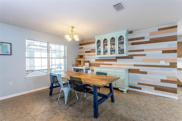 32 Karas Trl, Palm Coast, FL 32164 - dining space with a chandelier, a textured ceiling, and wooden walls
