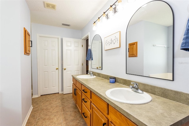 32 Karas Trl, Palm Coast, FL 32164 - full bathroom featuring double vanity, tile patterned floors, and a textured ceiling