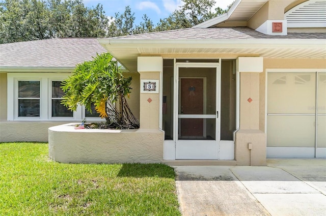 5 Wilksboro Pl, Palm Coast, FL 32164 - entrance to property with stucco siding, roof with shingles, and a lawn