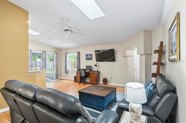 5 Wilksboro Pl, Palm Coast, FL 32164 - living room featuring a skylight, light wood-style flooring, vaulted ceiling, a desk, and a ceiling fan