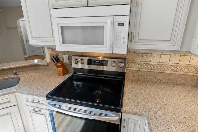 5 Wilksboro Pl, Palm Coast, FL 32164 - kitchen featuring stainless steel electric range oven, white microwave, tasteful backsplash, and white cabinetry