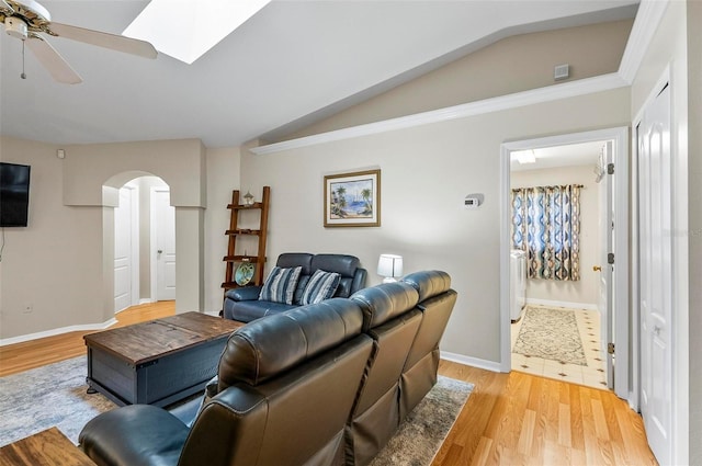 5 Wilksboro Pl, Palm Coast, FL 32164 - living area featuring lofted ceiling, arched walkways, ceiling fan, light wood-style floors, and a skylight