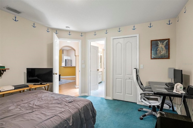 5 Wilksboro Pl, Palm Coast, FL 32164 - bedroom with freestanding refrigerator, a closet, arched walkways, carpet flooring, and an office area