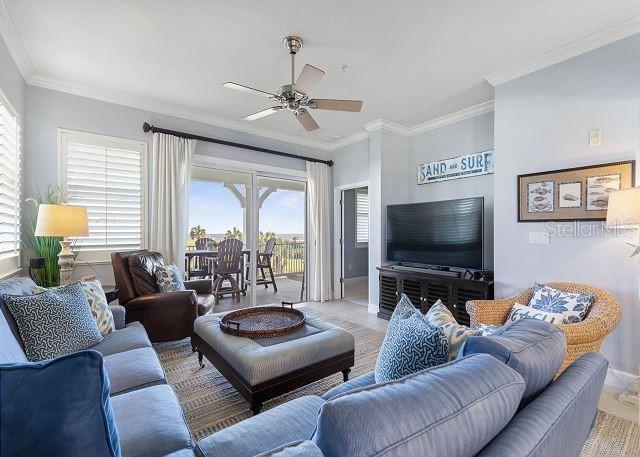 200 Cinnamon Beach Way Unit 131, Palm Coast, FL 32137 - living room featuring ceiling fan and crown molding