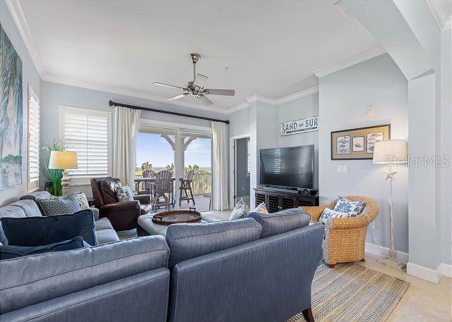 200 Cinnamon Beach Way Unit 131, Palm Coast, FL 32137 - living room with ceiling fan, ornamental molding, and light tile patterned flooring