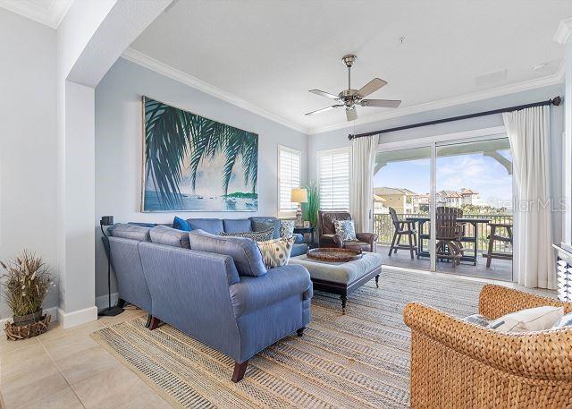 200 Cinnamon Beach Way Unit 131, Palm Coast, FL 32137 - living room featuring ceiling fan, ornamental molding, and light tile patterned flooring