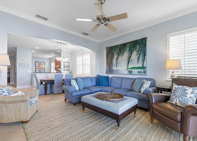 200 Cinnamon Beach Way Unit 131, Palm Coast, FL 32137 - living area featuring a ceiling fan, crown molding, and a chandelier