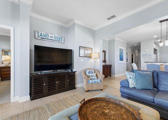 200 Cinnamon Beach Way Unit 131, Palm Coast, FL 32137 - living area featuring tile patterned flooring and crown molding