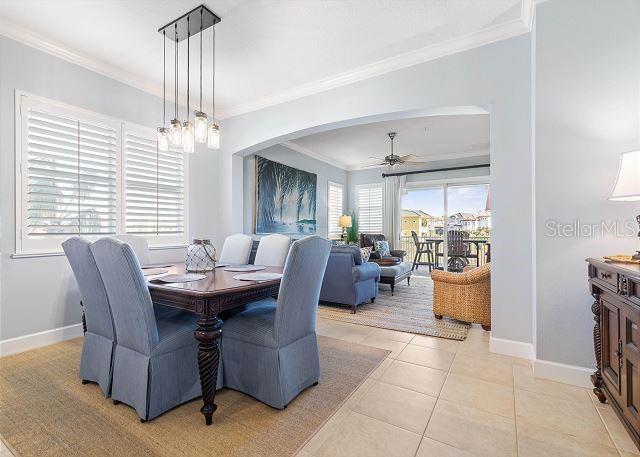 200 Cinnamon Beach Way Unit 131, Palm Coast, FL 32137 - dining room with ornamental molding, arched walkways, a ceiling fan, and light tile patterned flooring