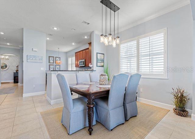 200 Cinnamon Beach Way Unit 131, Palm Coast, FL 32137 - dining room featuring ornamental molding, light tile patterned floors, a chandelier, arched walkways, and recessed lighting