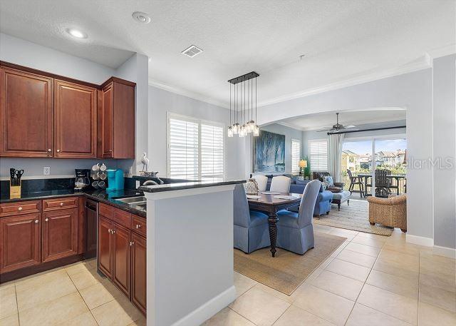 200 Cinnamon Beach Way Unit 131, Palm Coast, FL 32137 - kitchen featuring ornamental molding, dark countertops, healthy amount of natural light, light tile patterned floors, and recessed lighting