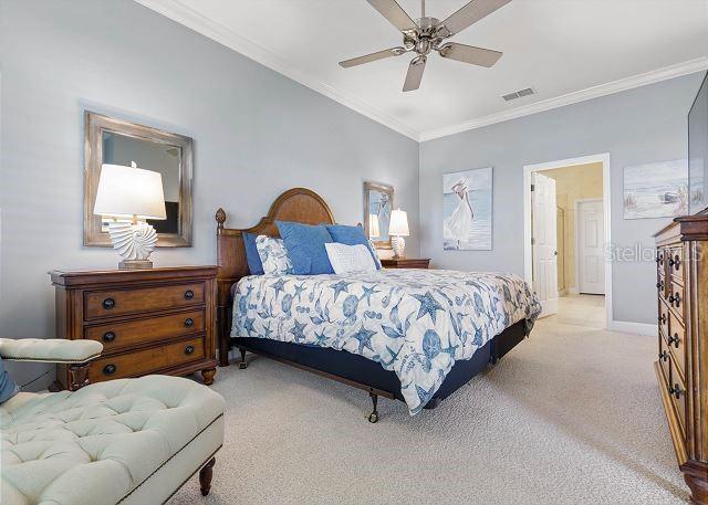 200 Cinnamon Beach Way Unit 131, Palm Coast, FL 32137 - bedroom featuring light colored carpet, ornamental molding, and a ceiling fan