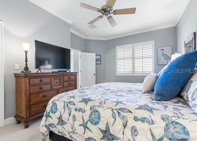 200 Cinnamon Beach Way Unit 131, Palm Coast, FL 32137 - carpeted bedroom featuring crown molding and a ceiling fan