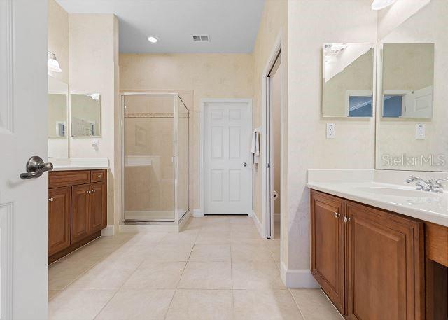 200 Cinnamon Beach Way Unit 131, Palm Coast, FL 32137 - bathroom featuring a stall shower, vanity, and tile patterned flooring