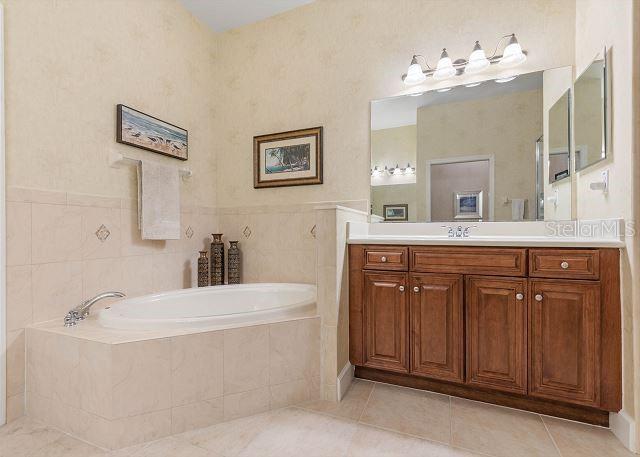 200 Cinnamon Beach Way Unit 131, Palm Coast, FL 32137 - full bathroom featuring vanity, a bath, and tile patterned flooring
