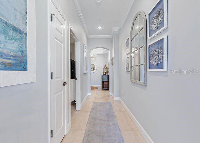 200 Cinnamon Beach Way Unit 131, Palm Coast, FL 32137 - hallway featuring light tile patterned floors, ornamental molding, and arched walkways