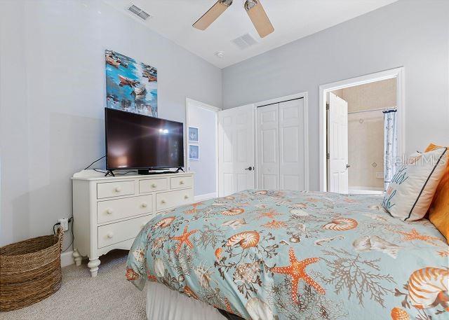 200 Cinnamon Beach Way Unit 131, Palm Coast, FL 32137 - bedroom with light carpet, ceiling fan, a closet, and ensuite bathroom