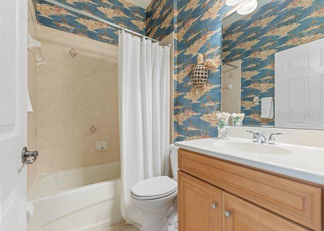 200 Cinnamon Beach Way Unit 131, Palm Coast, FL 32137 - bathroom with wallpapered walls, vanity, and shower / tub combo
