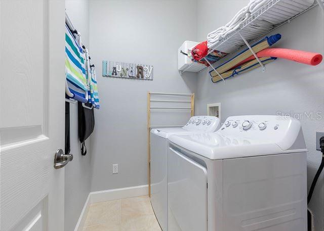 200 Cinnamon Beach Way Unit 131, Palm Coast, FL 32137 - laundry area featuring washing machine and clothes dryer and light tile patterned floors